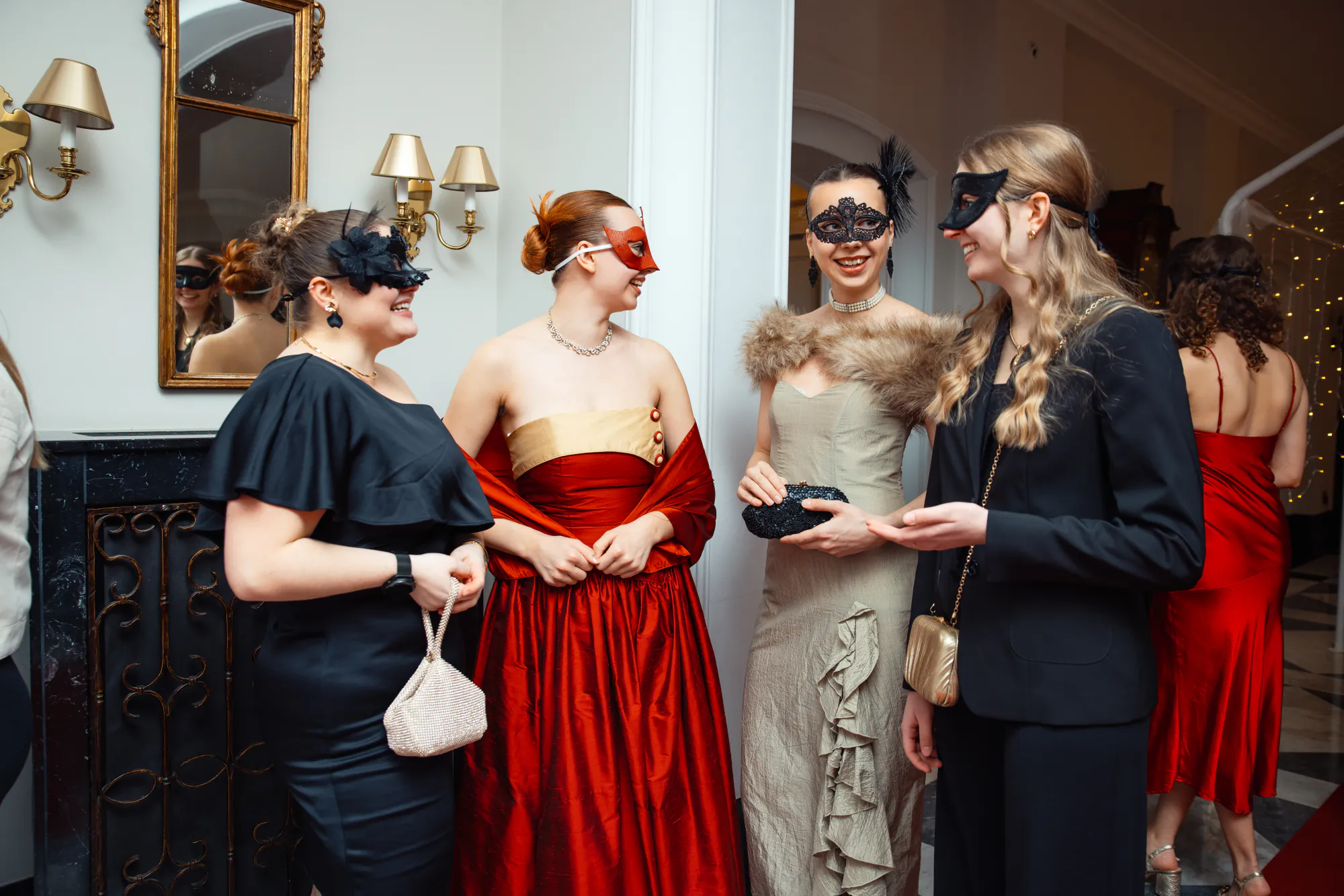 Gäste in Masken und Abendkleidern im Foyer, Weihnachtsfeier im Fairmont Hotel Vier Jahreszeiten Hamburg